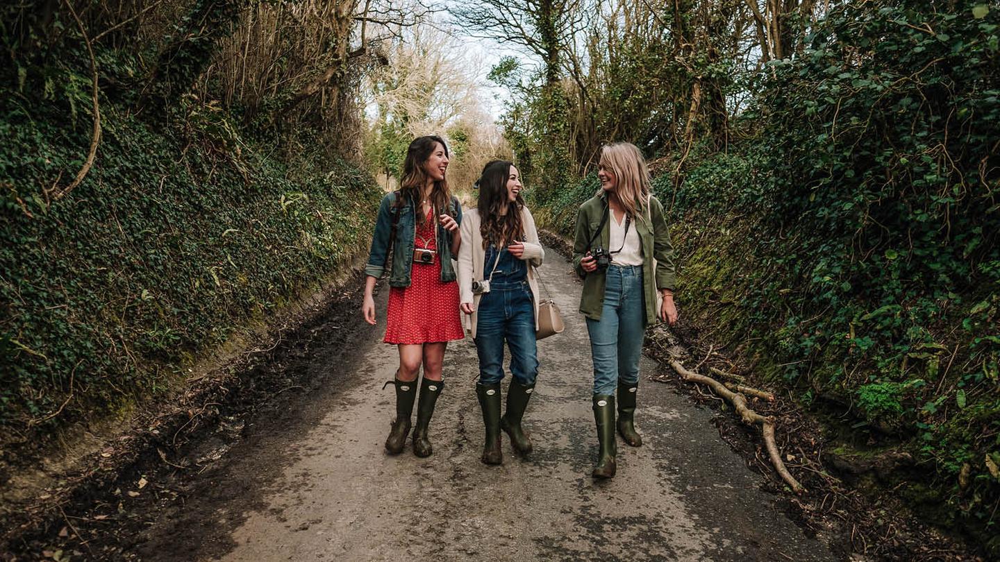 The girls taking a walk through the woods, wearing wellies and other FatFace clothing. 